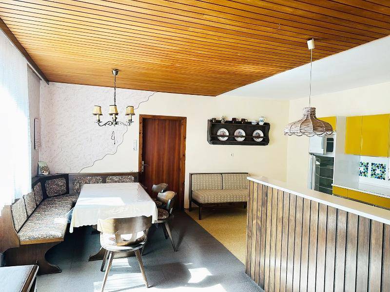 Essbereich mit Holztäfelung an der Decke und einer gemütlichen Eckbank, angrenzend an die Küche.