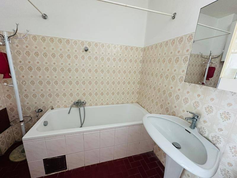 Badezimmer mit Badewanne, Waschbecken und gemusterten Fliesen im traditionellen Stil.