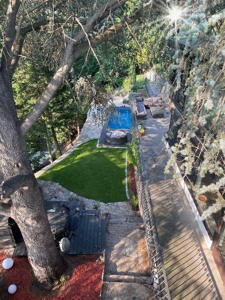 Vogelperspektive des Anwesens mit Pool, Rasenfläche und mehreren Terrassenbereichen.