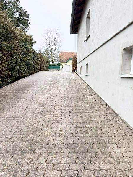 Lange gepflasterte Auffahrt, die zum hinteren Bereich des Grundstücks führt.