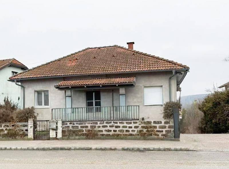 Einfamilienhaus mit Ziegeldach und einer kleinen Veranda im Eingangsbereich.