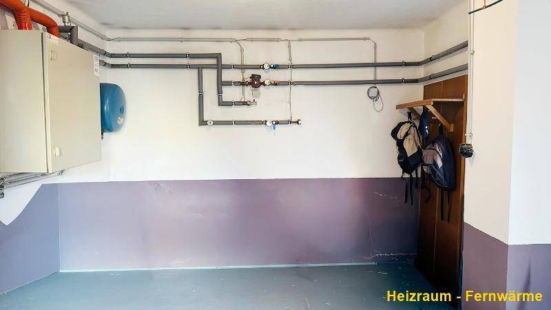 Heizraum mit sichtbaren Rohrleitungen und technischer Ausstattung für die Fernwärmeversorgung.