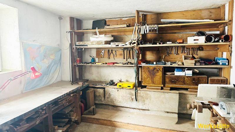 Funktionale Werkstatt mit umfangreichen Holzregalen, Werkzeugen und Arbeitsflächen.