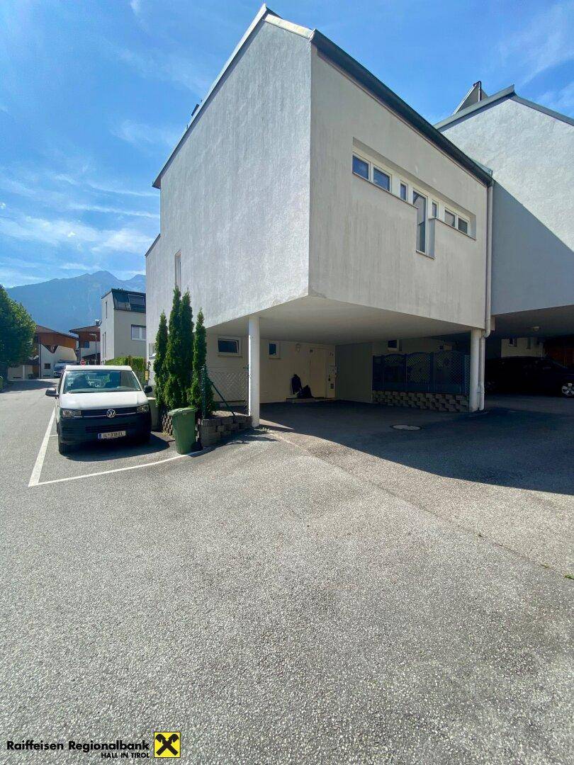 Moderne Wohnanlage mit überdachten Parkplätzen und klarem architektonischem Design.