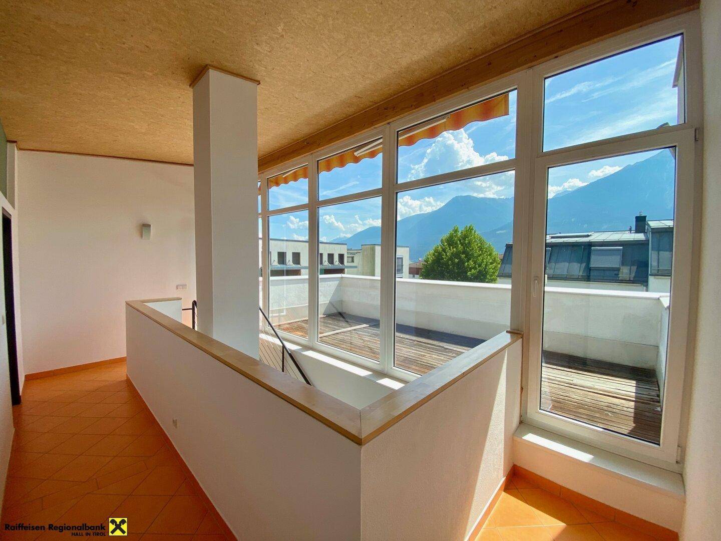 Heller Flur im Obergeschoss mit großen Fenstern und weitem Bergblick.