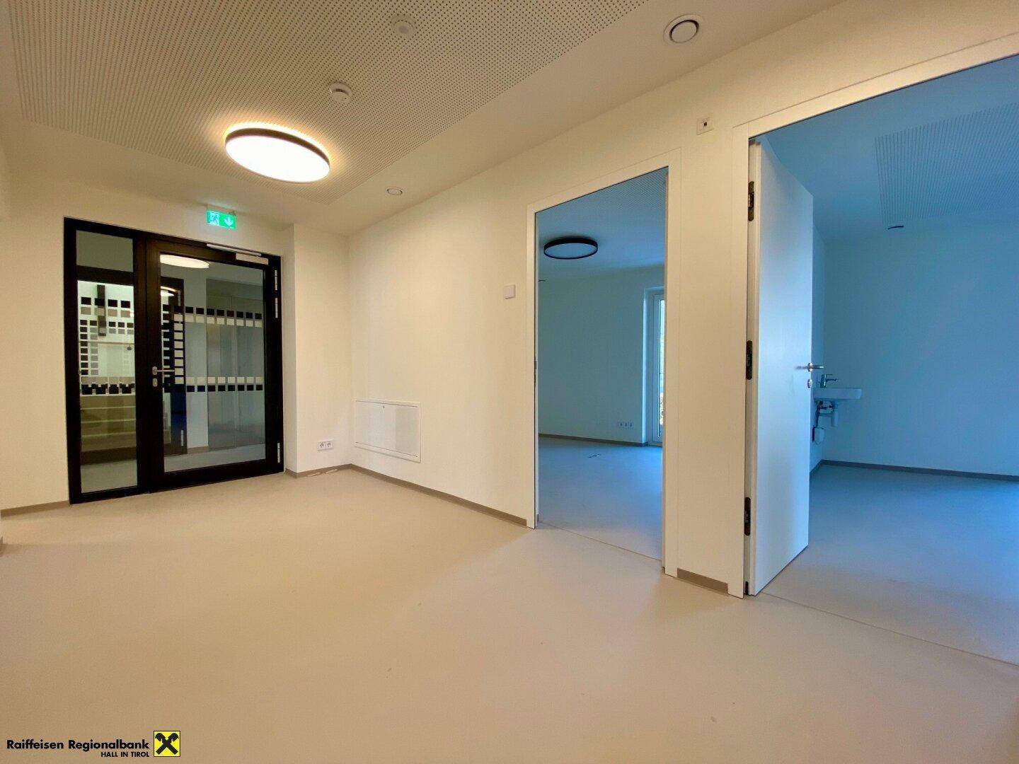 Geräumiger Eingangsbereich mit hellem Vinylboden, moderner Deckenbeleuchtung und Zugang zu angrenzenden Zimmern.