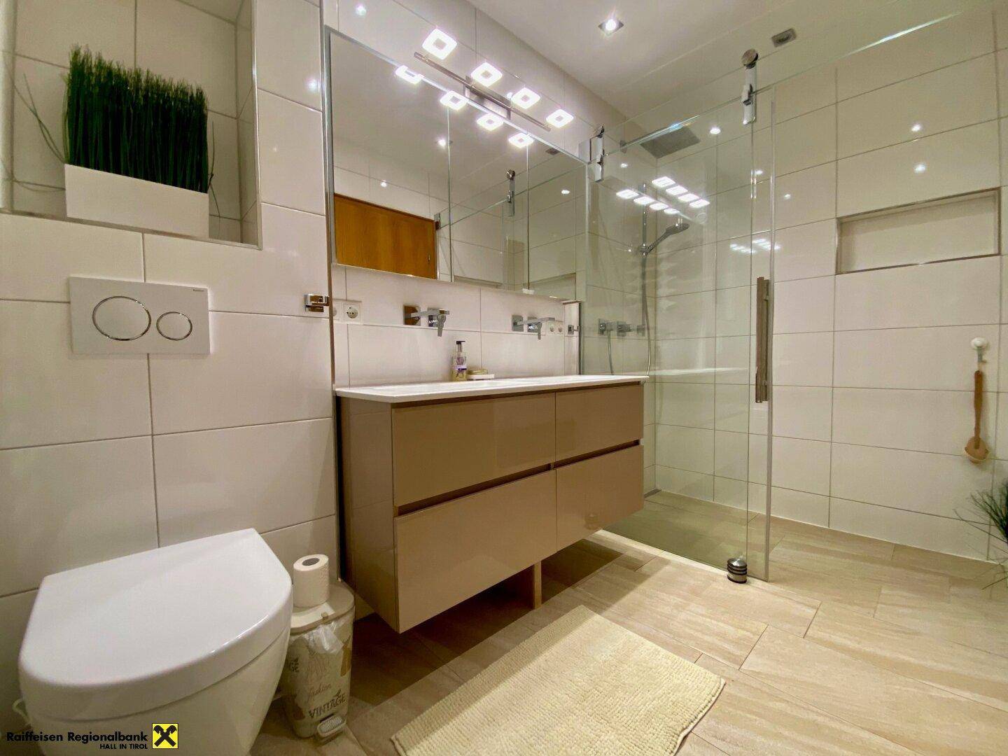 Modernes Badezimmer mit begehbarer Dusche, Wand-WC und großem Spiegelschrank.