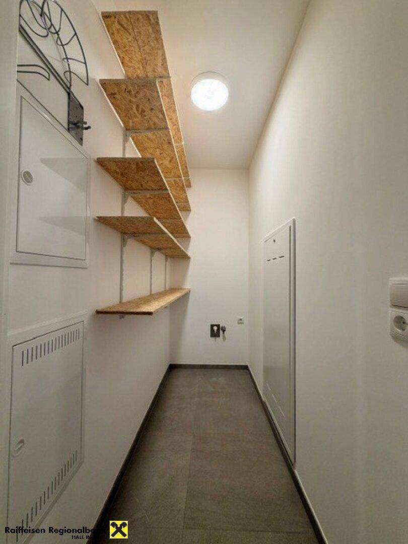 Praktischer Abstellraum mit offenen Holzregalen und ausreichend Stauraum für Haushaltsgegenstände.