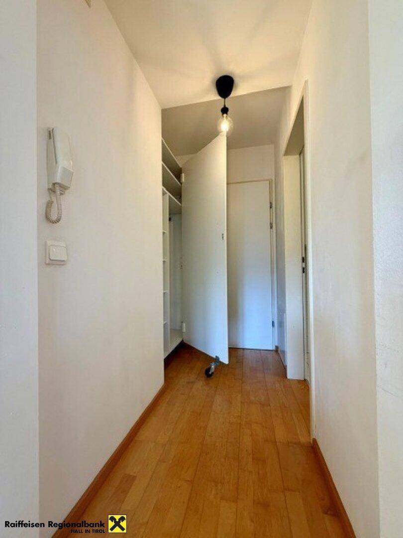 Heller Flur mit Parkettboden und praktischem Einbauschrank für zusätzlichen Stauraum.