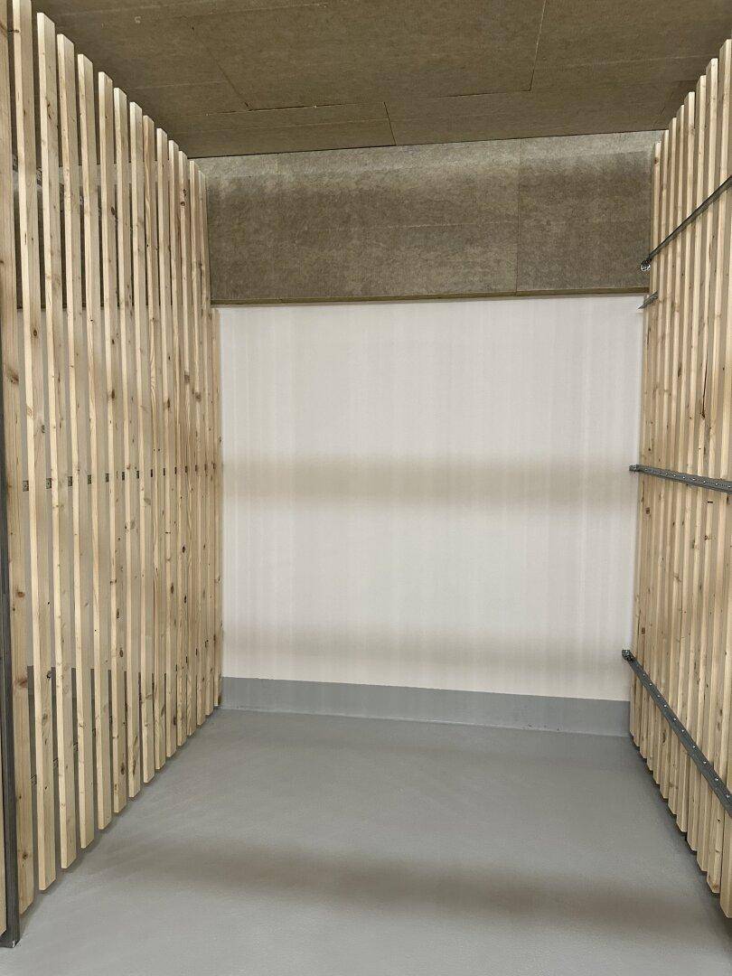 Geräumiger Kellerabteil mit Holzlattenwänden und Betonboden, ideal für zusätzlichen Stauraum.