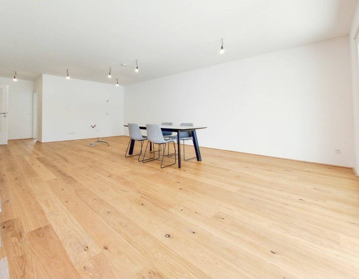 Geräumiger Essbereich mit hellem Eichenparkettboden und modernen Esszimmermöbeln in minimalistischem Design.