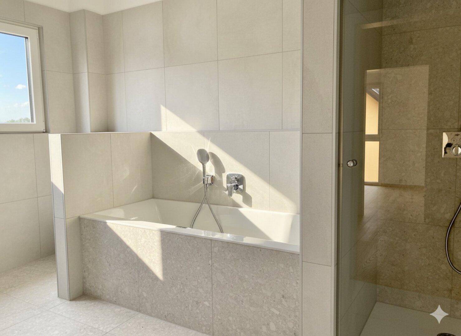 Modernes Badezimmer mit eingebauter Badewanne und begehbarer Dusche, hell gefliest.