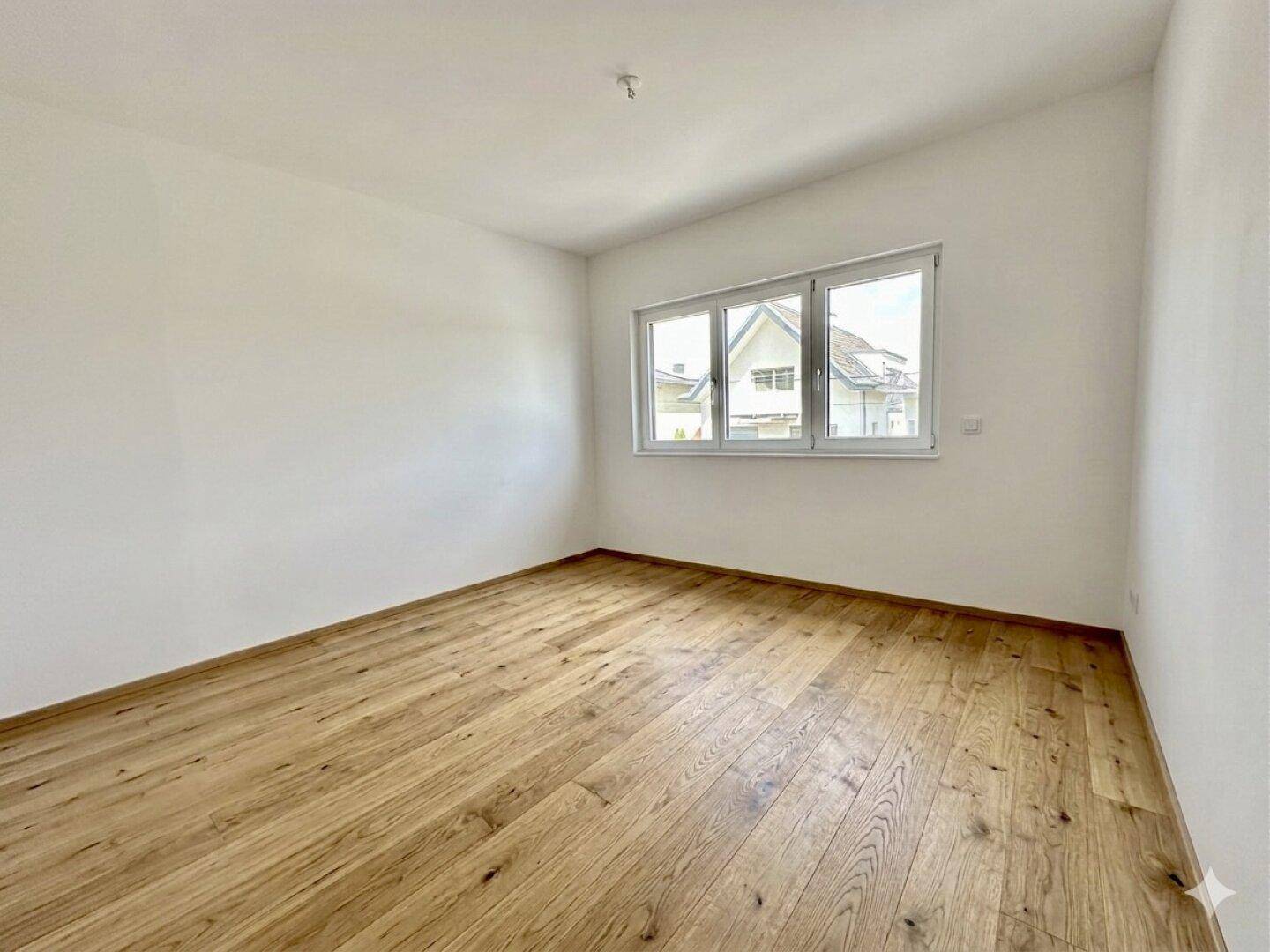 Helles Schlafzimmer mit Holzboden und Dachschräge, bietet eine gemütliche Atmosphäre und viel Tageslicht.