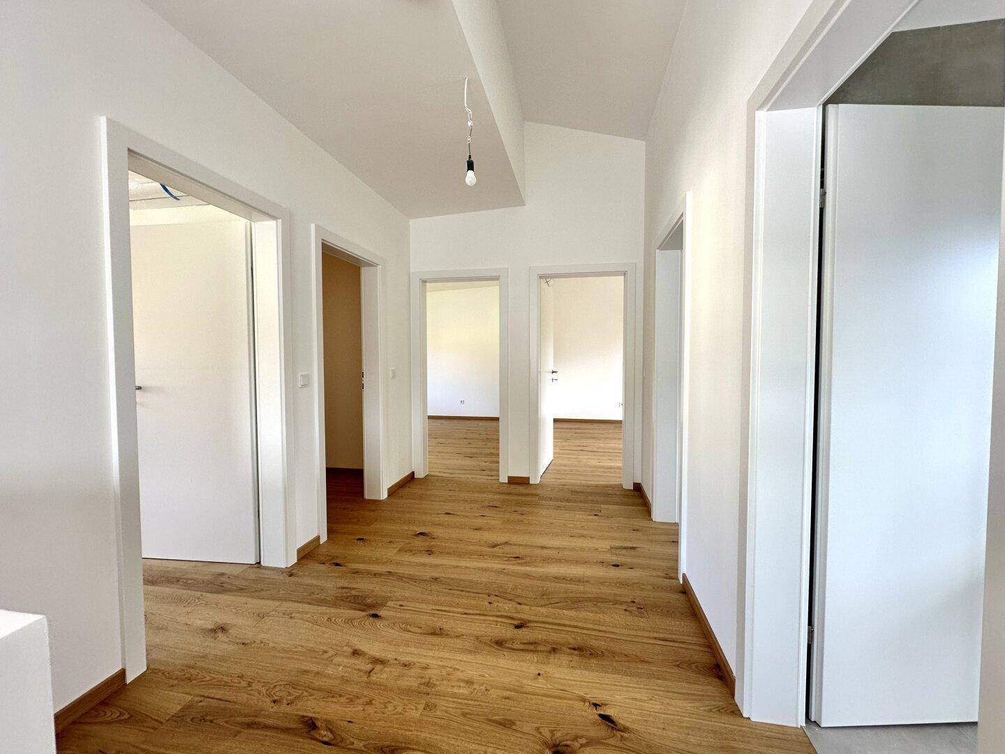 Geräumiger Flur mit Holzboden und mehreren Türen, die zu den angrenzenden Zimmern führen.