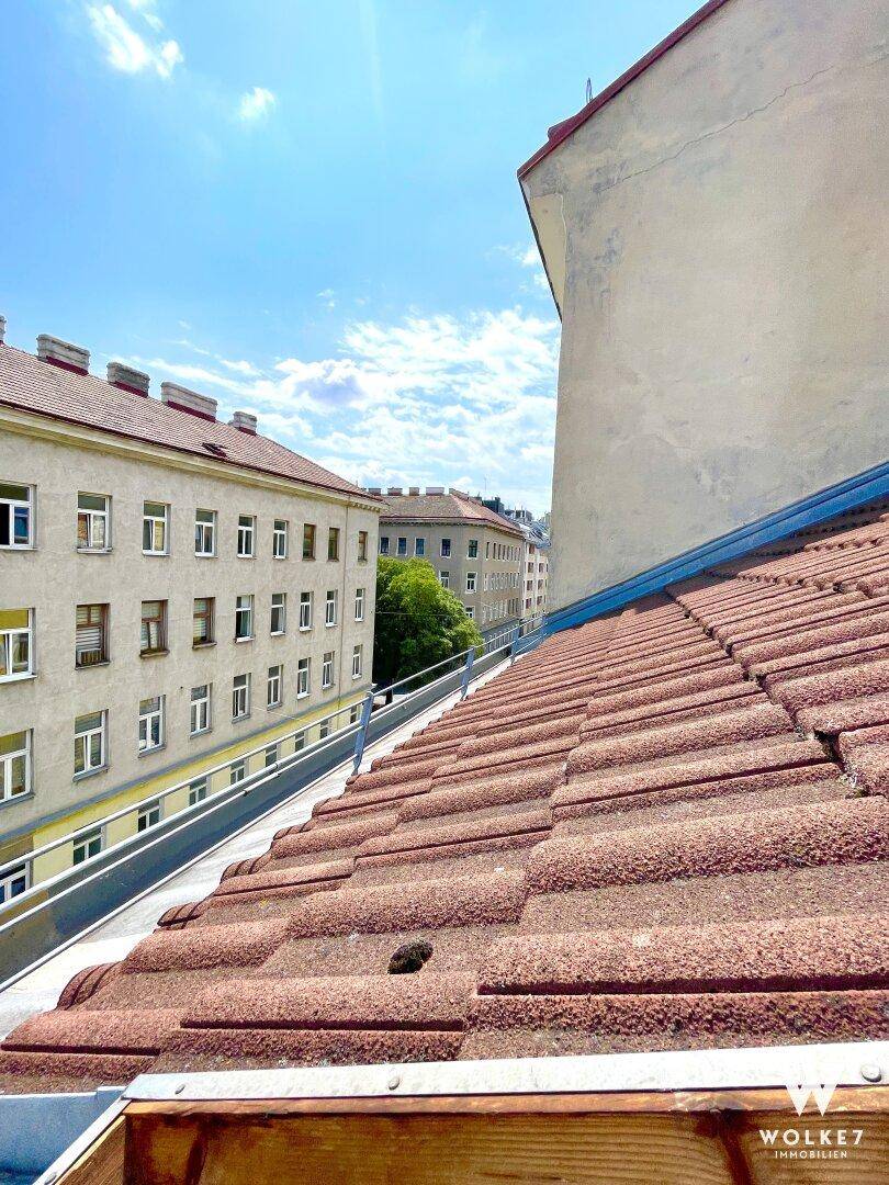 Panoramablick über die Dächer der Stadt mit roten Ziegeln und angrenzenden Gebäuden unter blauem Himmel.