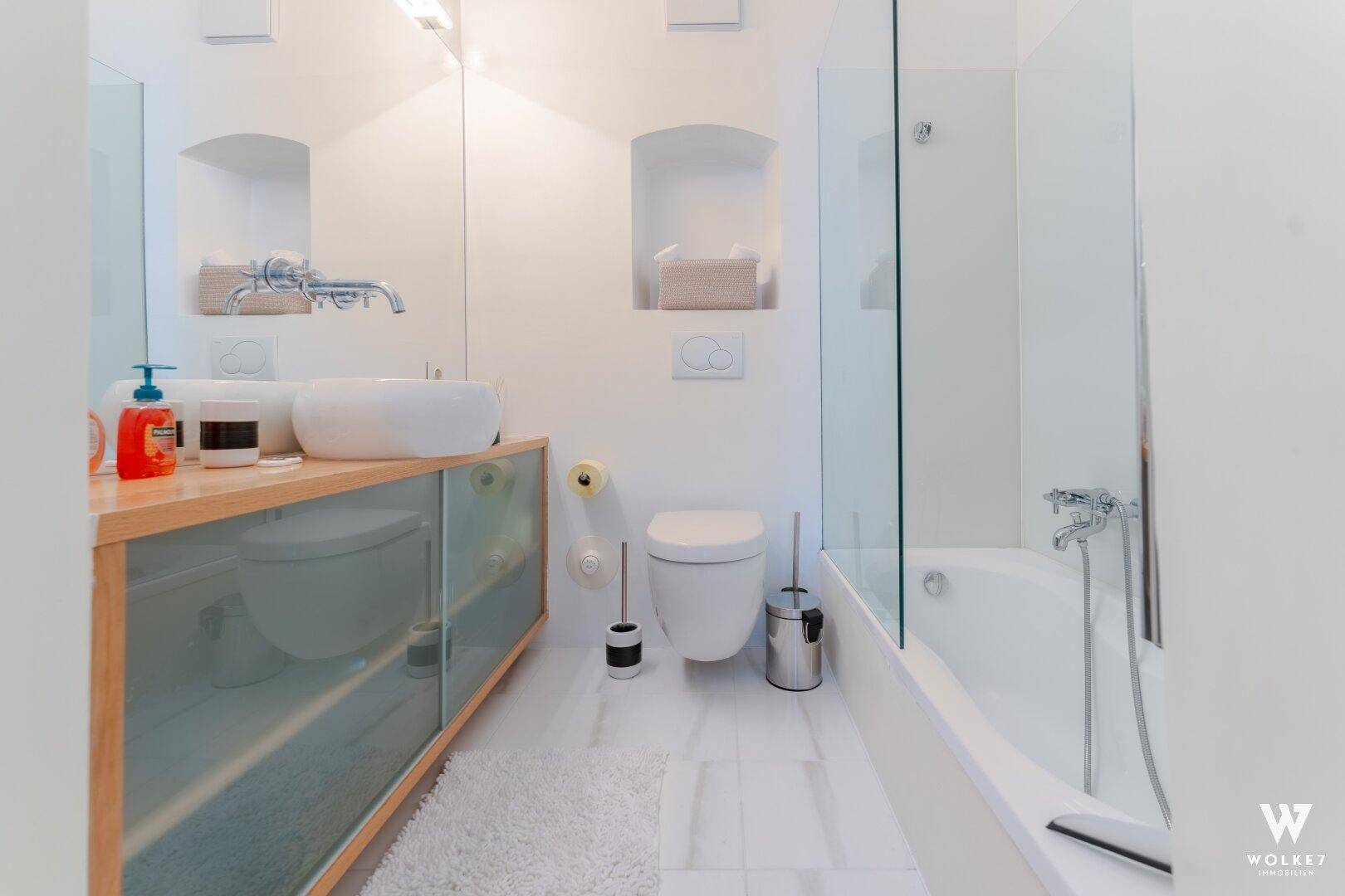Modernes Badezimmer mit Badewanne, wandhängendem WC und stilvollem Waschbecken.