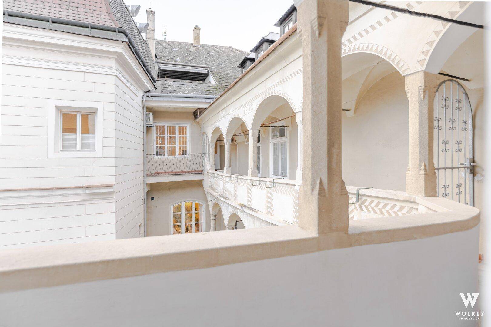 Historischer Innenhof mit Arkaden und traditioneller Architektur, der einen charmanten Blick bietet.