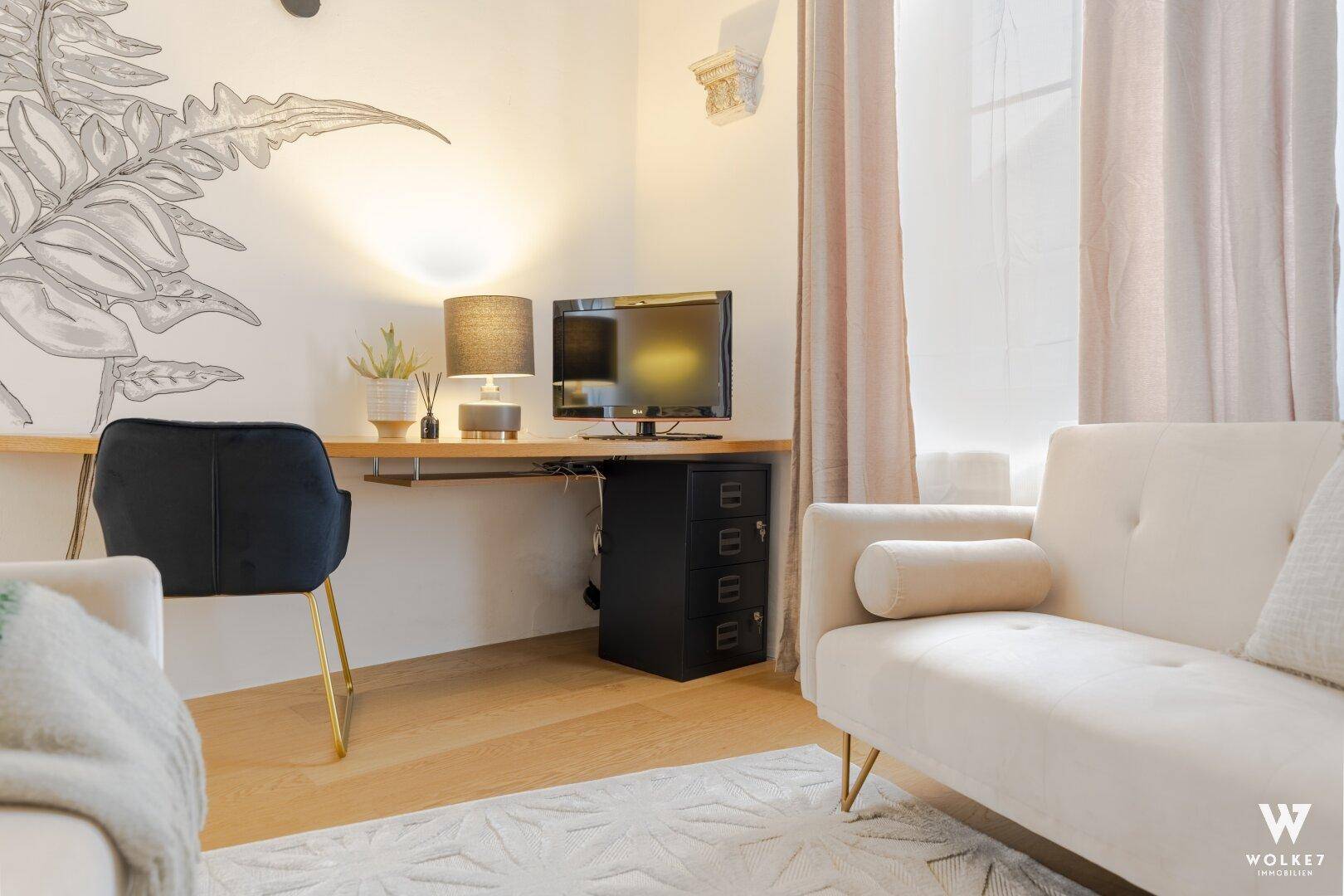 Funktionaler Arbeitsbereich mit Schreibtisch und Monitor, integriert in einen hellen Wohnraum.