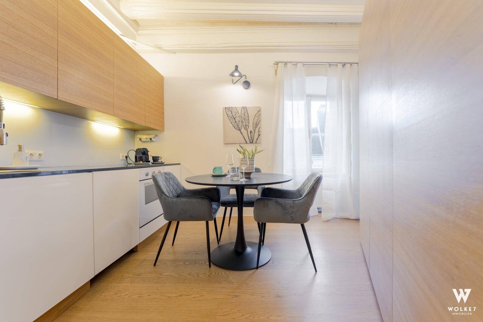 Moderne Küche mit Essbereich, Holzelementen und hellem Ambiente, ideal für gemeinsame Mahlzeiten.
