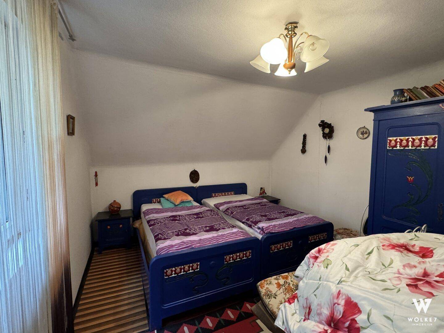 Schlafzimmer im Dachgeschoss mit zwei Einzelbetten und schrägen Decken.