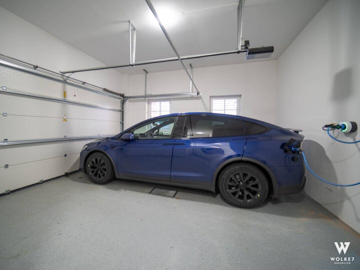 Garage mit Ladestation für Elektrofahrzeuge und automatischem Garagentor.