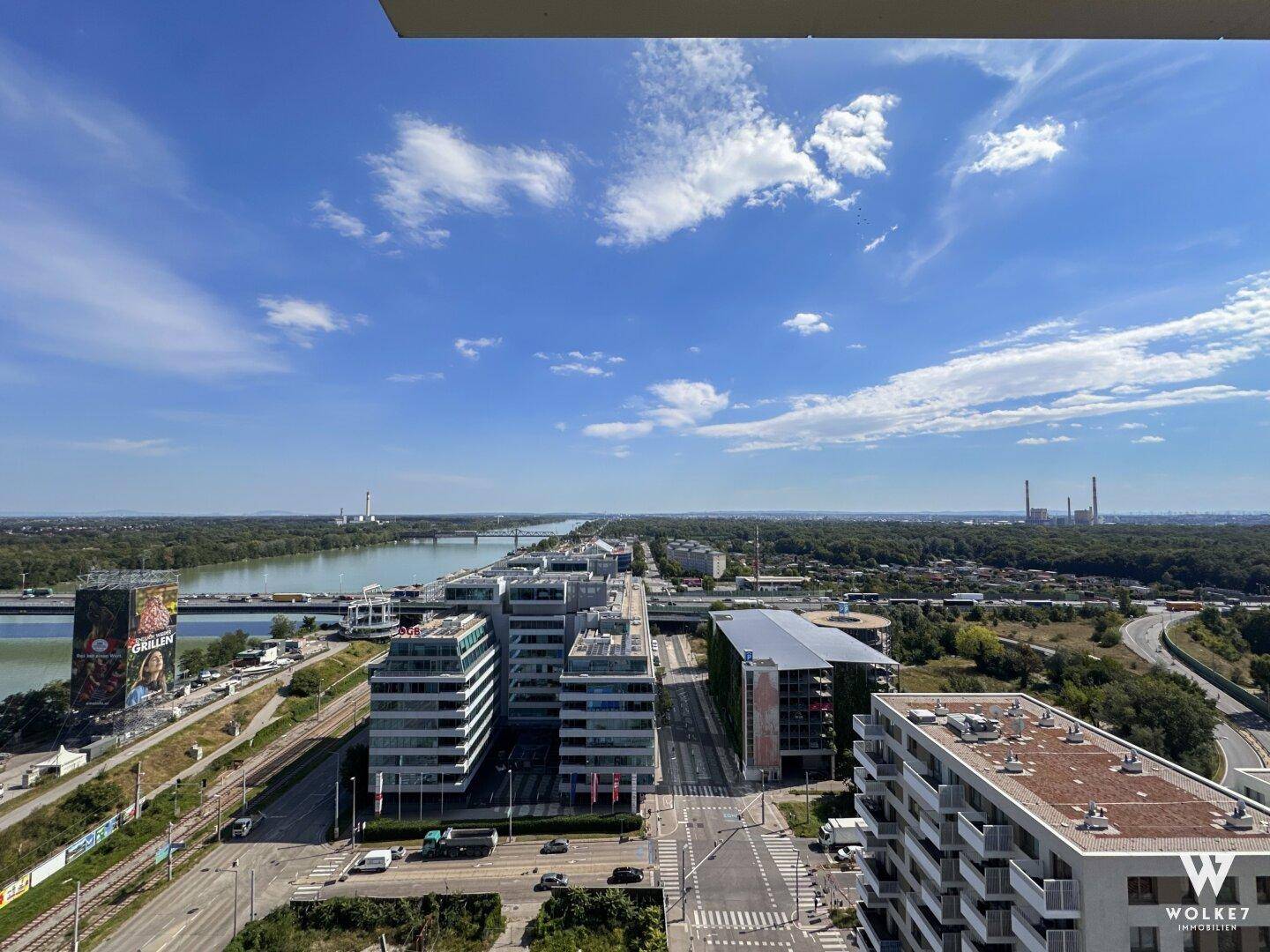 Weitläufiger Blick über die Stadt, einen Fluss und die umliegende Landschaft von oben.