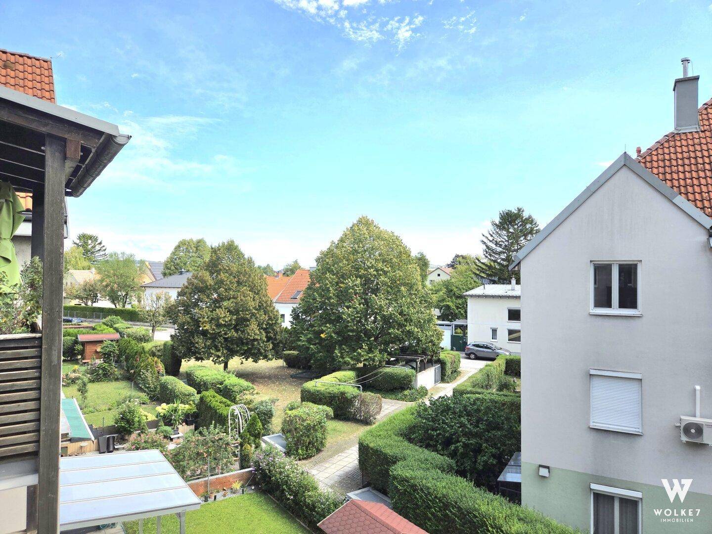 Weitläufiger Blick über gepflegte Gärten und die umliegende Nachbarschaft.