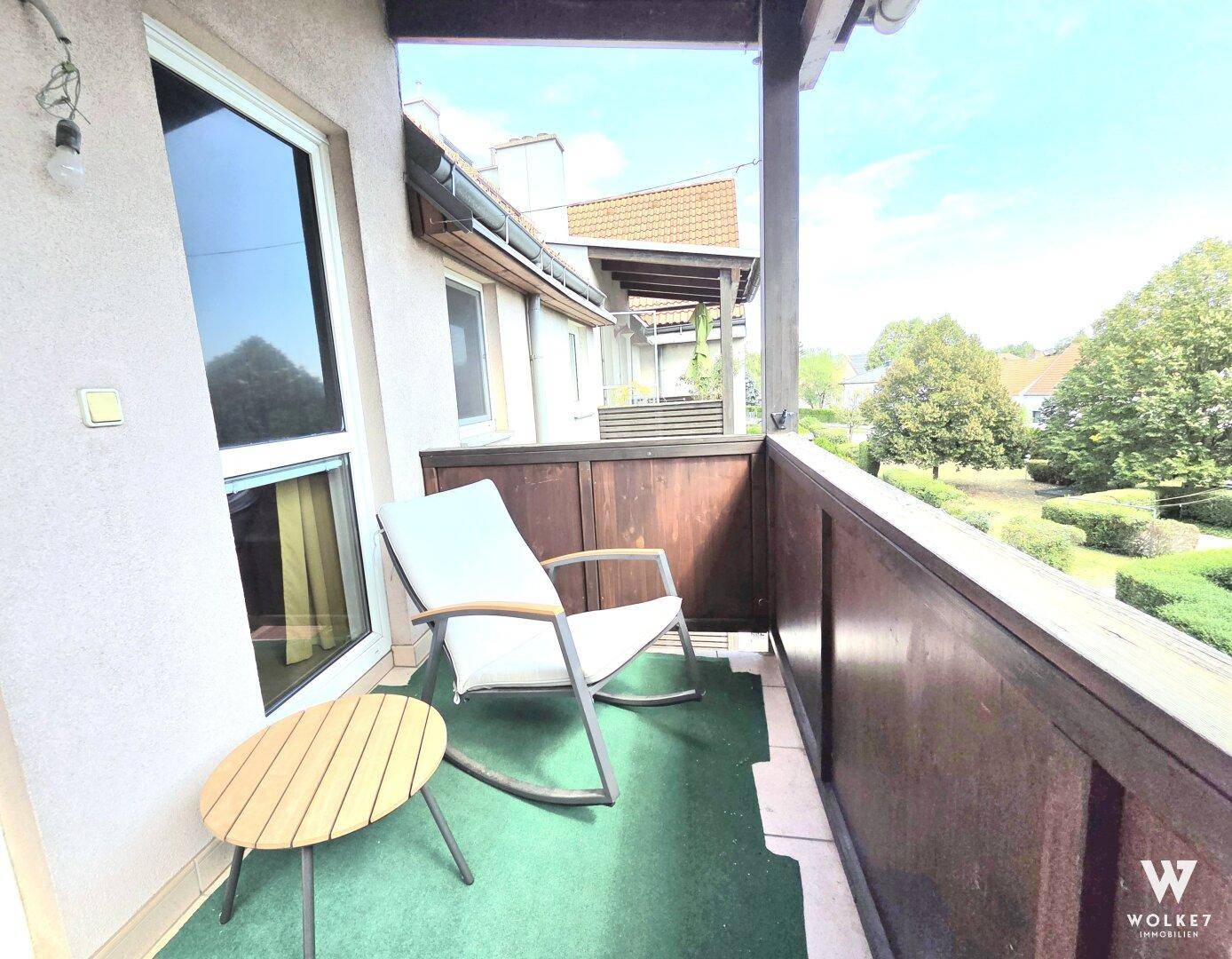 Gemütlicher Balkon mit Sitzgelegenheiten und Blick ins Grüne.