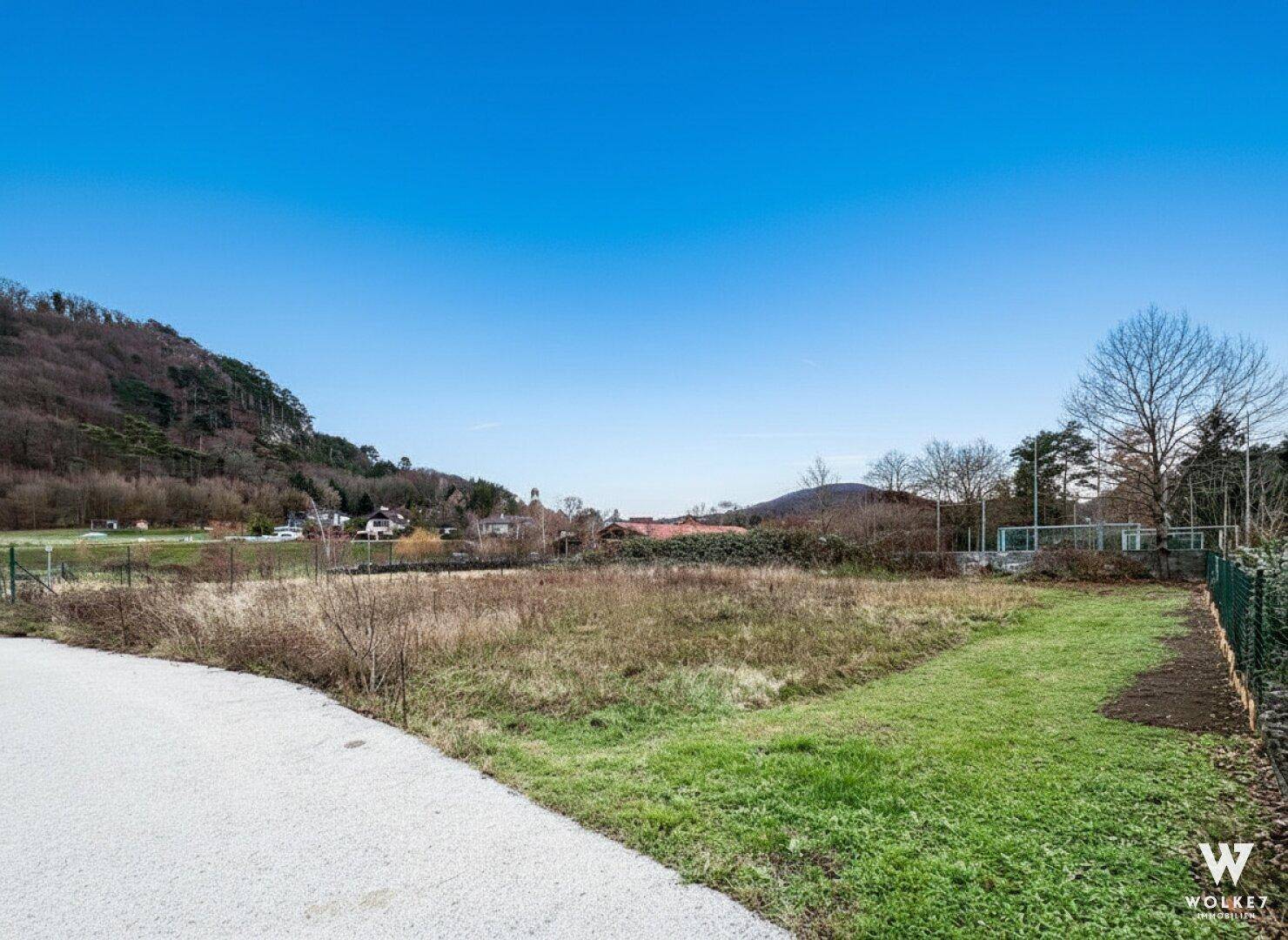 Großes Grundstück mit Grasfläche und Blick auf bewaldete Hügel und die weitere Umgebung.