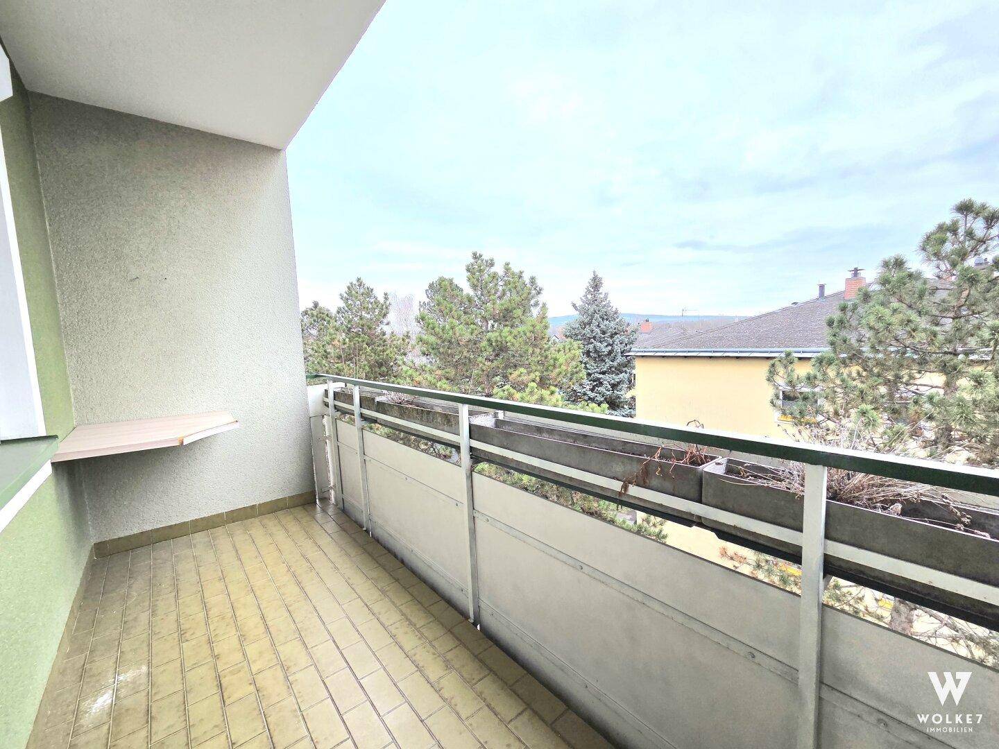 Balkon mit Fliesenboden und Blick ins Grüne, ideal für entspannte Stunden im Freien.