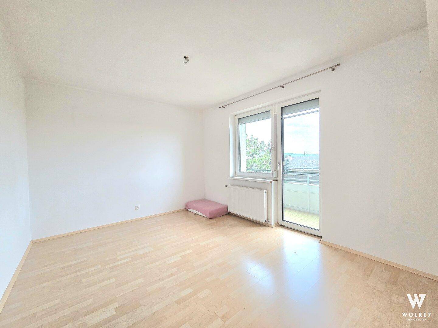 Helles Zimmer mit Parkettboden und Zugang zum Balkon, vielseitig nutzbar als Schlaf- oder Arbeitszimmer.