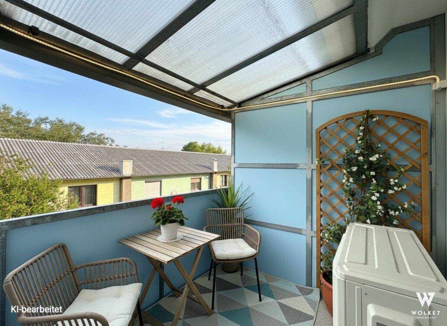 Gemütlicher, überdachter Balkon mit Sitzgelegenheiten und Blick auf die Umgebung.