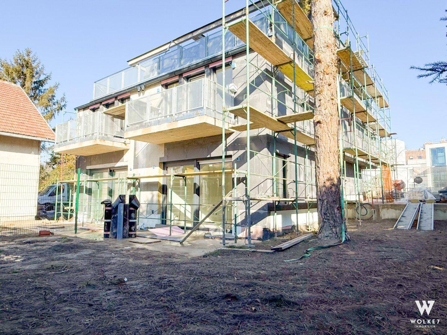 Neubau im Bauzustand mit Gerüst an der Fassade und unfertigem Gartenbereich.