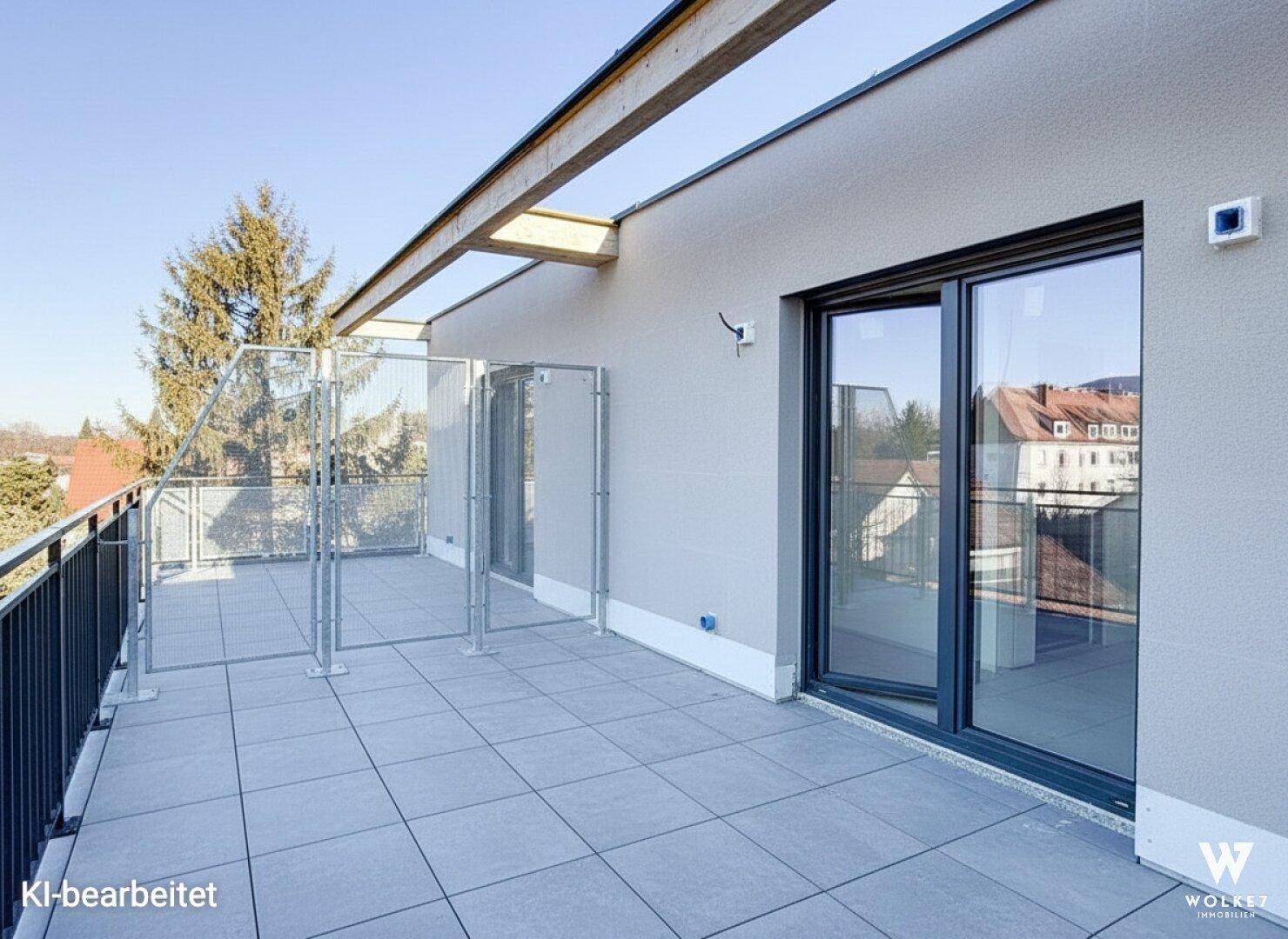 Geräumige Dachterrasse mit Fliesenboden und Metallgeländer, bietet weite Aussicht.