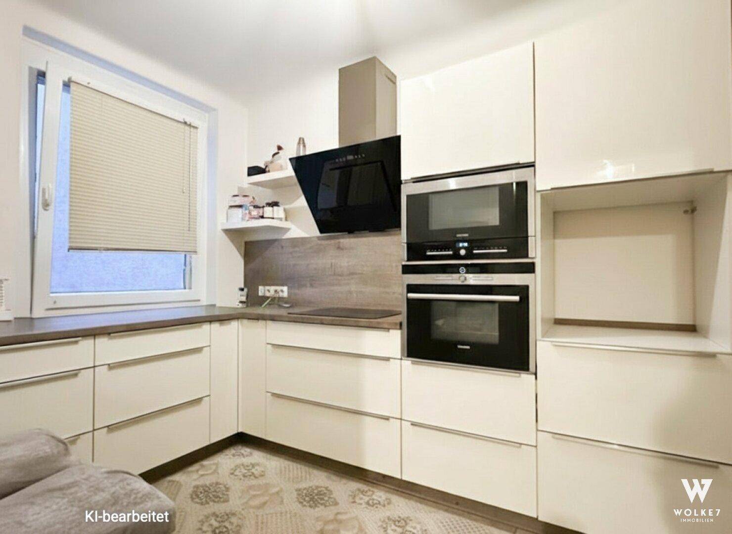 Moderne Einbauküche mit hellen Fronten, integrierten Geräten und einem Fenster für Tageslicht.