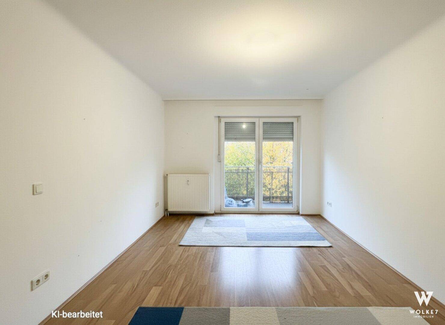Leeres Zimmer mit Holzfußboden und direktem Zugang zu einem Balkon, ideal zur individuellen Gestaltung.
