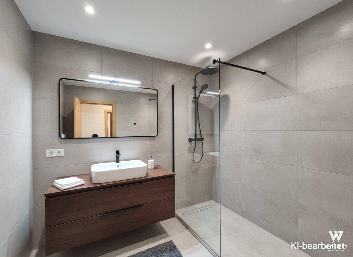 Modernes Badezimmer mit großformatigen grauen Fliesen, ebenerdiger Dusche und stilvollem Waschtisch.