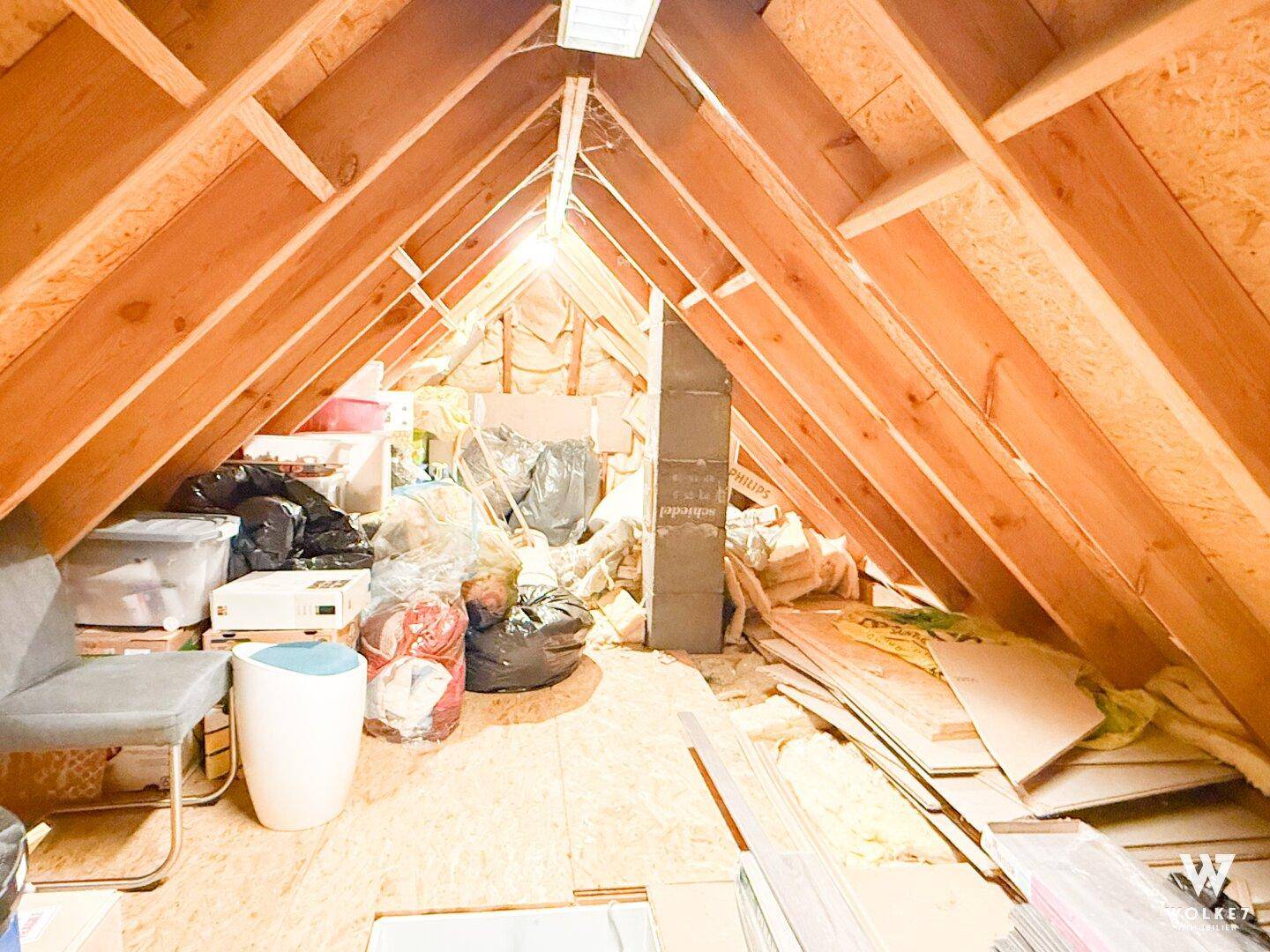 Geräumiger Dachboden mit sichtbaren Holzbalken, der als Abstellraum genutzt wird.