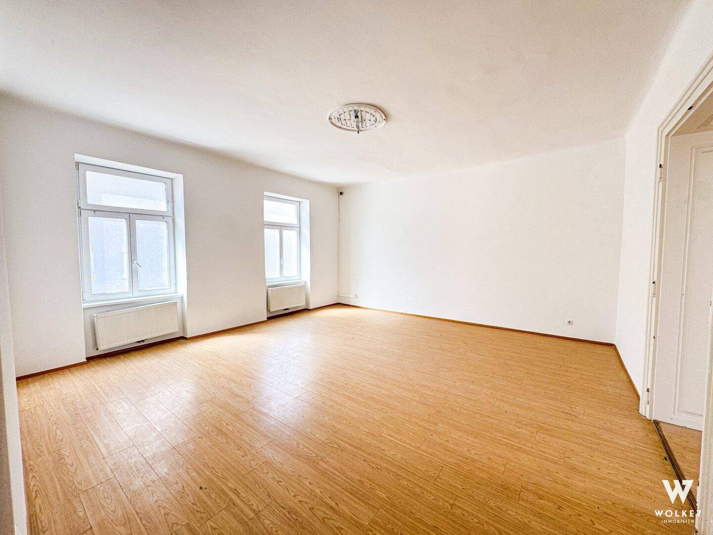 Geräumiges, leeres Büro mit hellen Wänden und Laminatboden, ideal für individuelle Gestaltung.