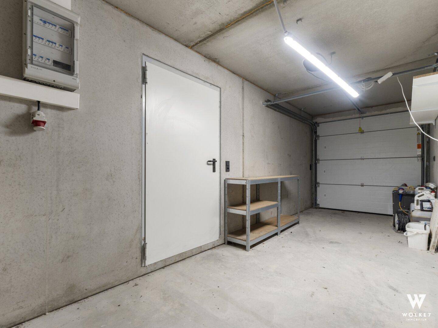Praktischer Abstellraum mit Betonwänden und Metallregal, ideal für Lagerzwecke.