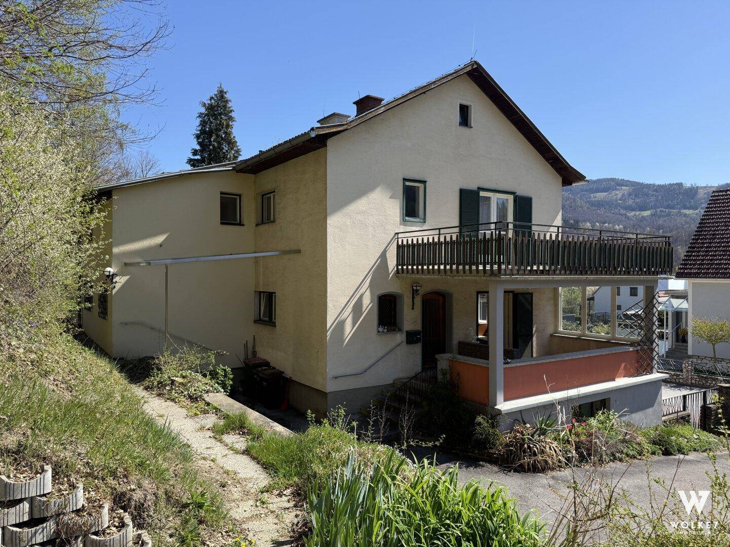 Seitenansicht des Hauses mit Balkon und Zugang zum Gartenbereich.