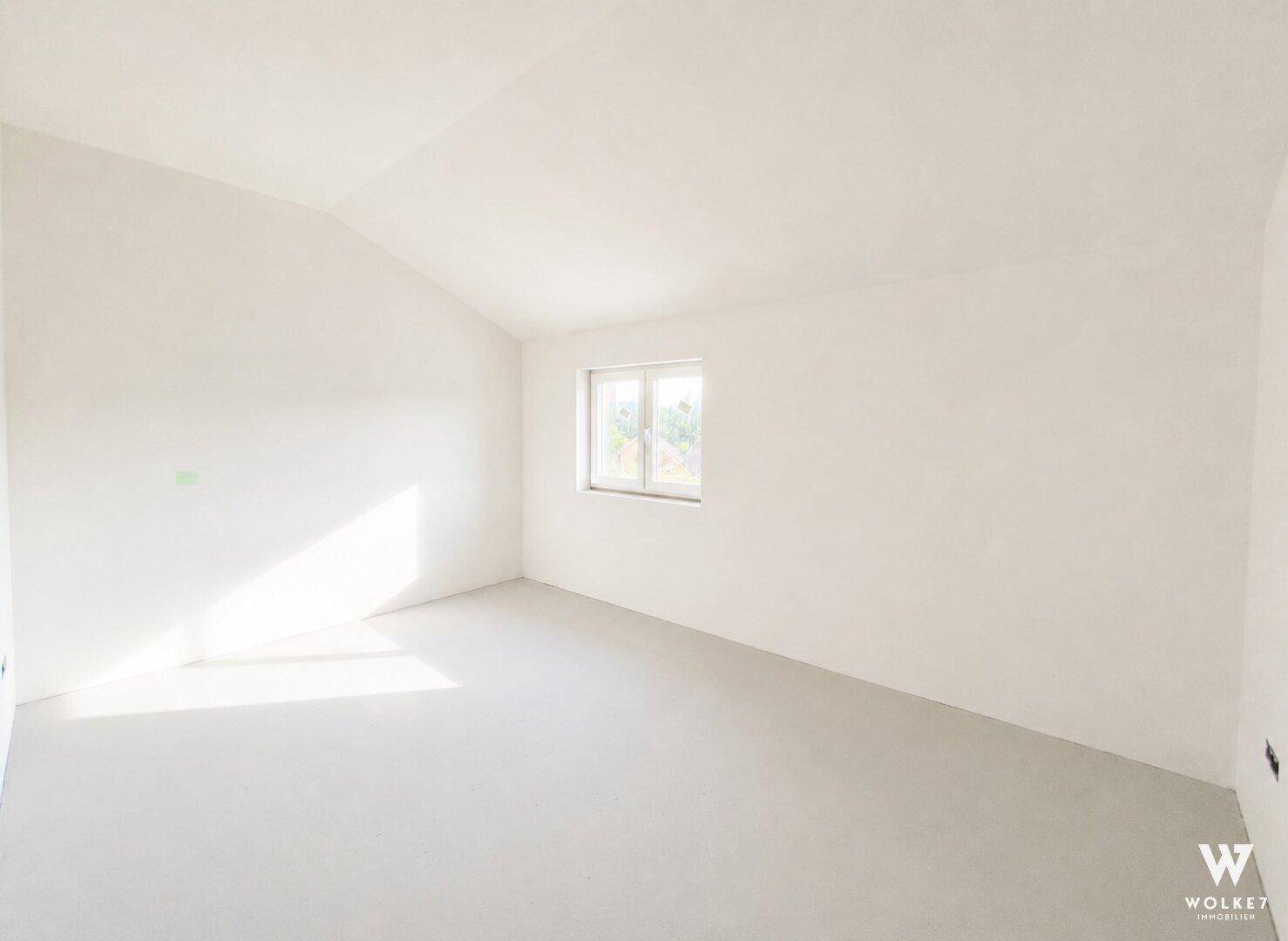 Unmöblierter Raum im Dachgeschoss mit Dachschräge und Fenster, gut belichtet.