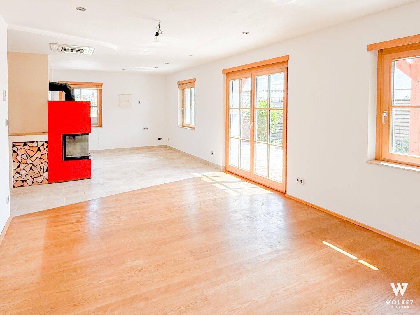 Heller Wohnbereich mit modernem Kamin und Holzboden, bereit zur individuellen Gestaltung.