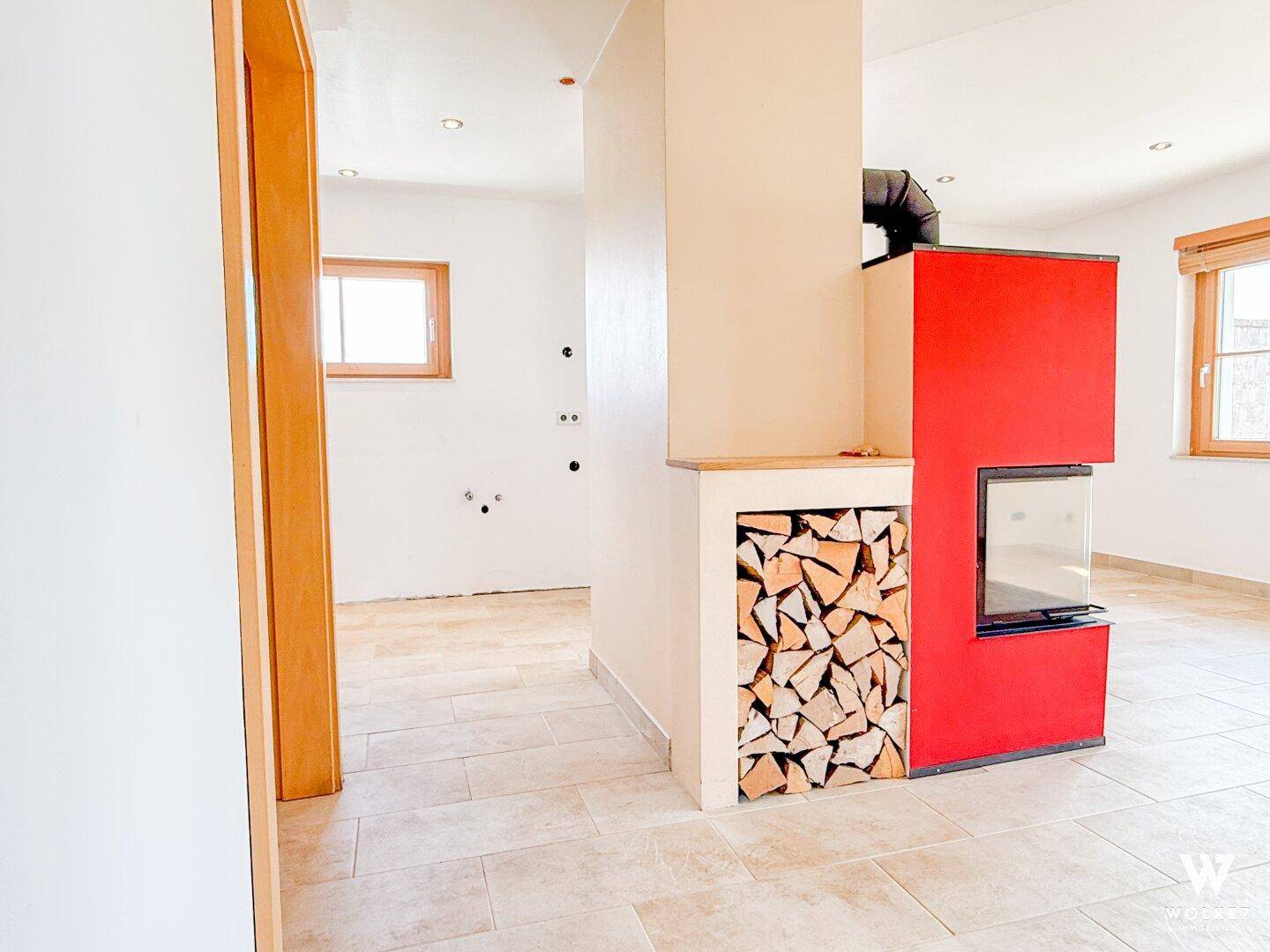 Heller Durchgangsbereich mit modernem Kamin und integriertem Holzregal.