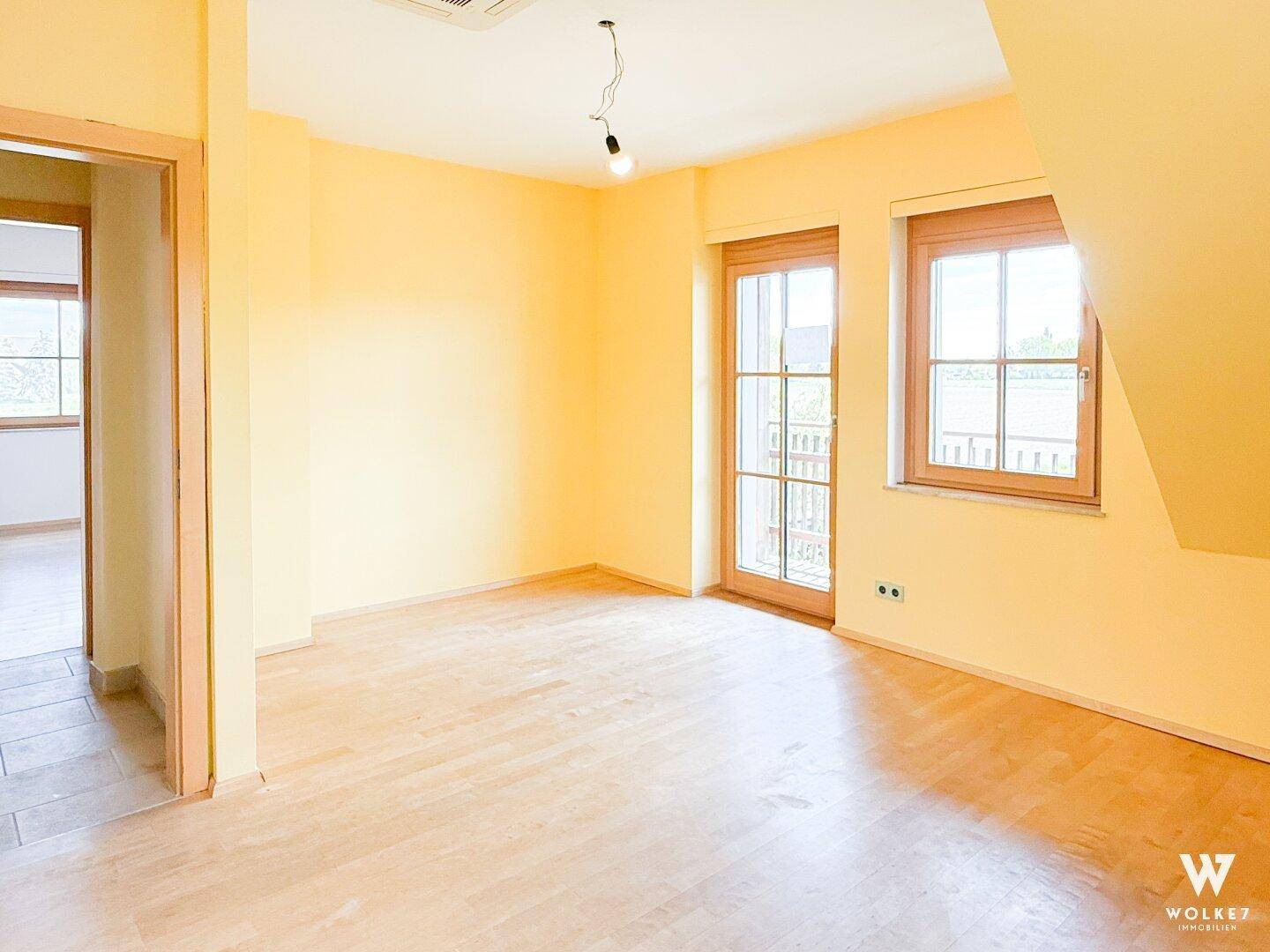 Helles Schlafzimmer mit Holzboden und Zugang zu einem Balkon, ideal für erholsame Nächte.