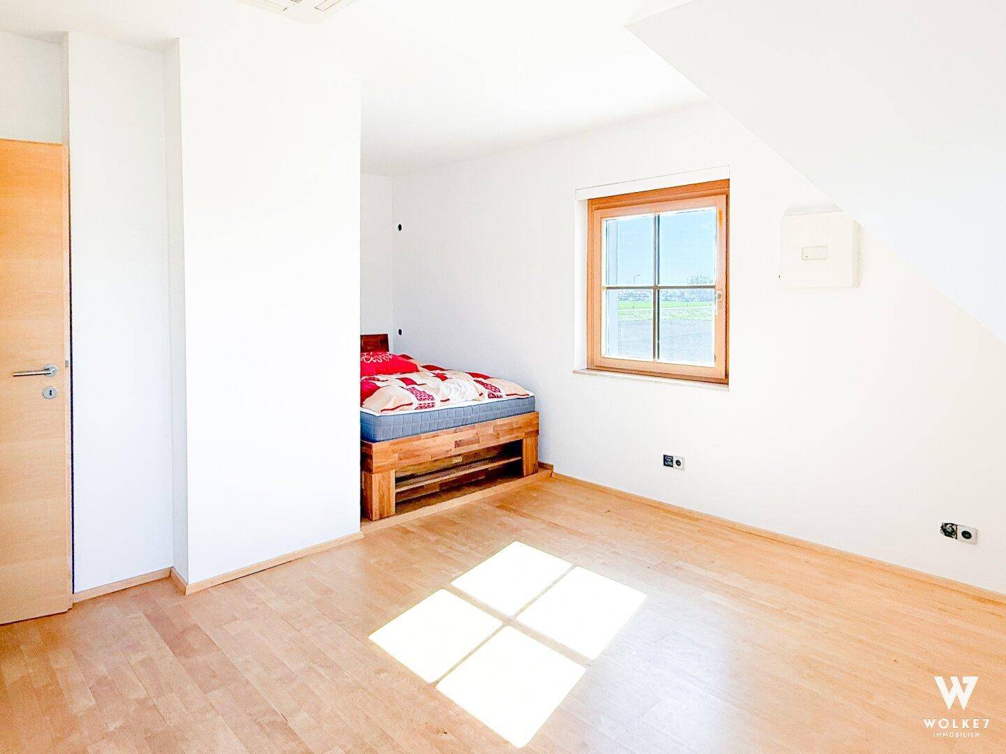 Gemütliches Schlafzimmer mit Holzbett und Holzboden, ideal für ein Kinder- oder Gästezimmer.