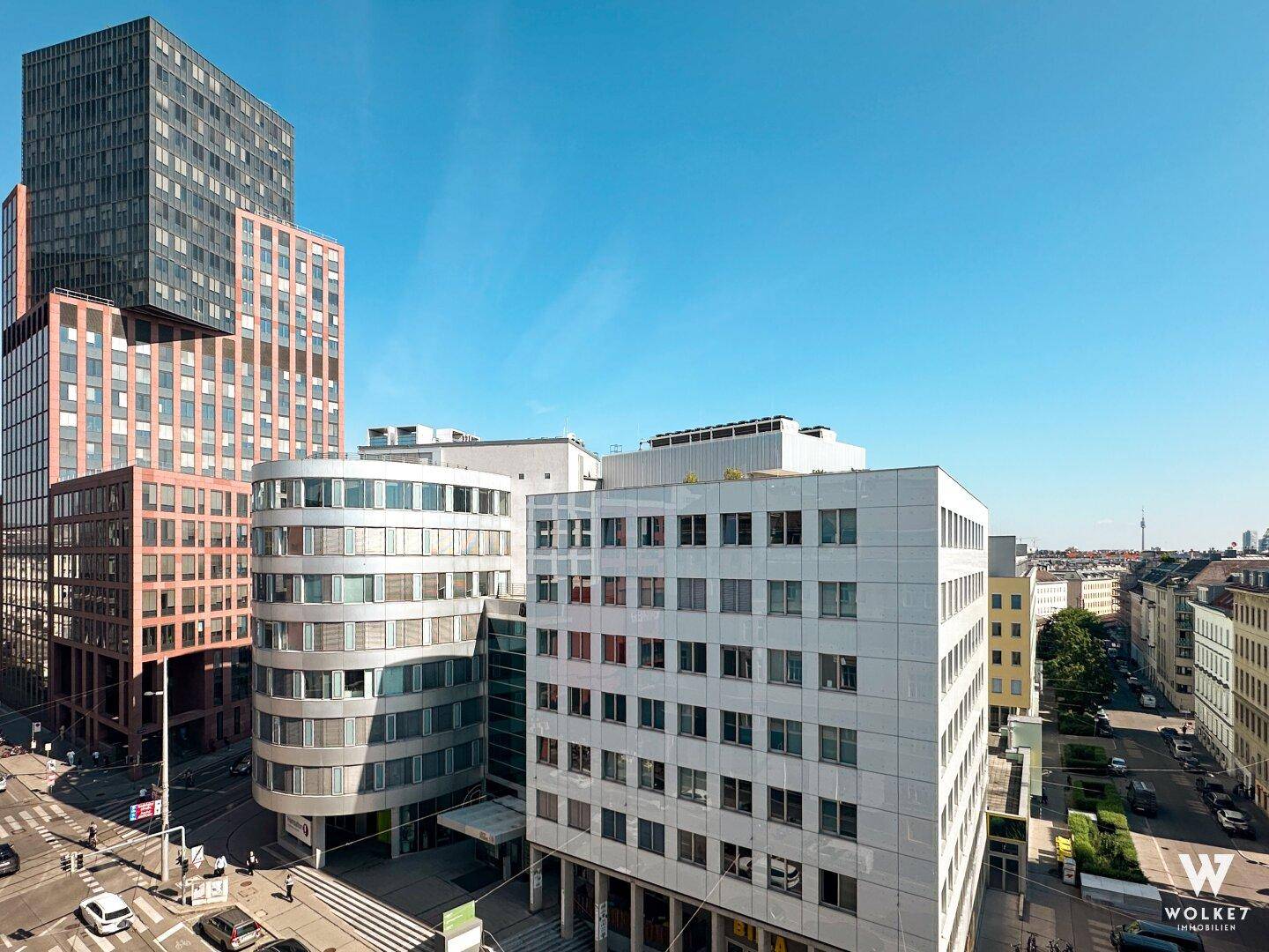 Stadtansicht mit verschiedenen modernen Gebäuden und einer weiten Himmelslinie im Hintergrund.