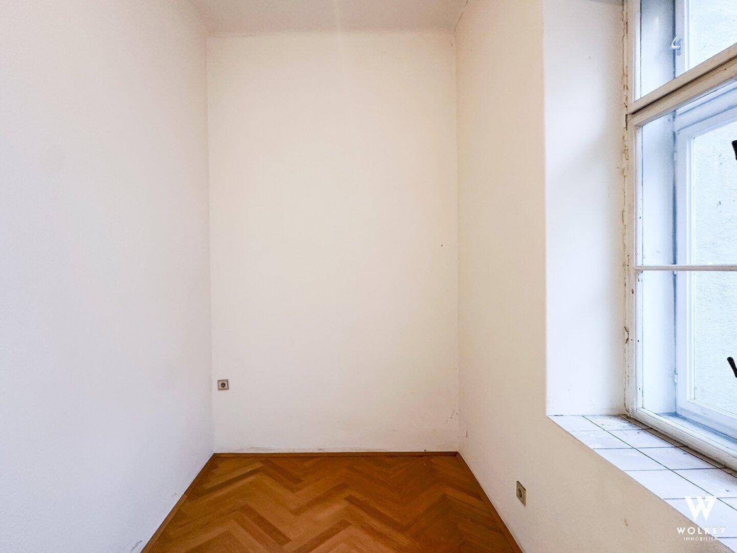 Kompaktes Zimmer mit Fischgrätparkett und einem Fenster, geeignet für individuelle Nutzung.