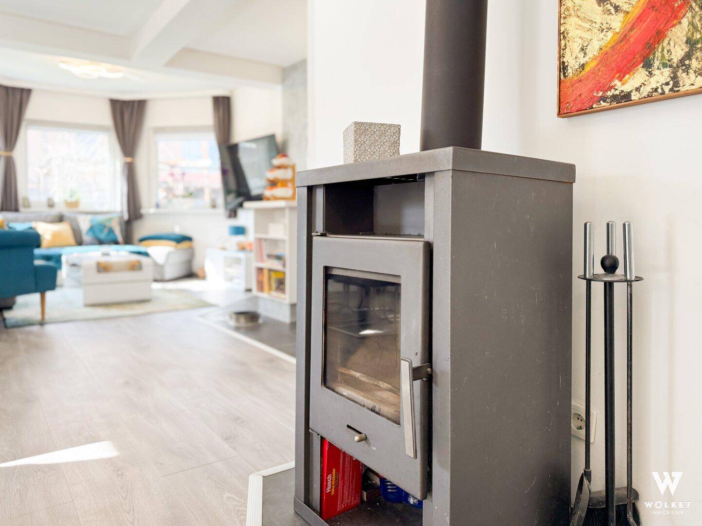 Moderner Holzofen im offenen Wohnbereich, der Wärme und Gemütlichkeit spendet.
