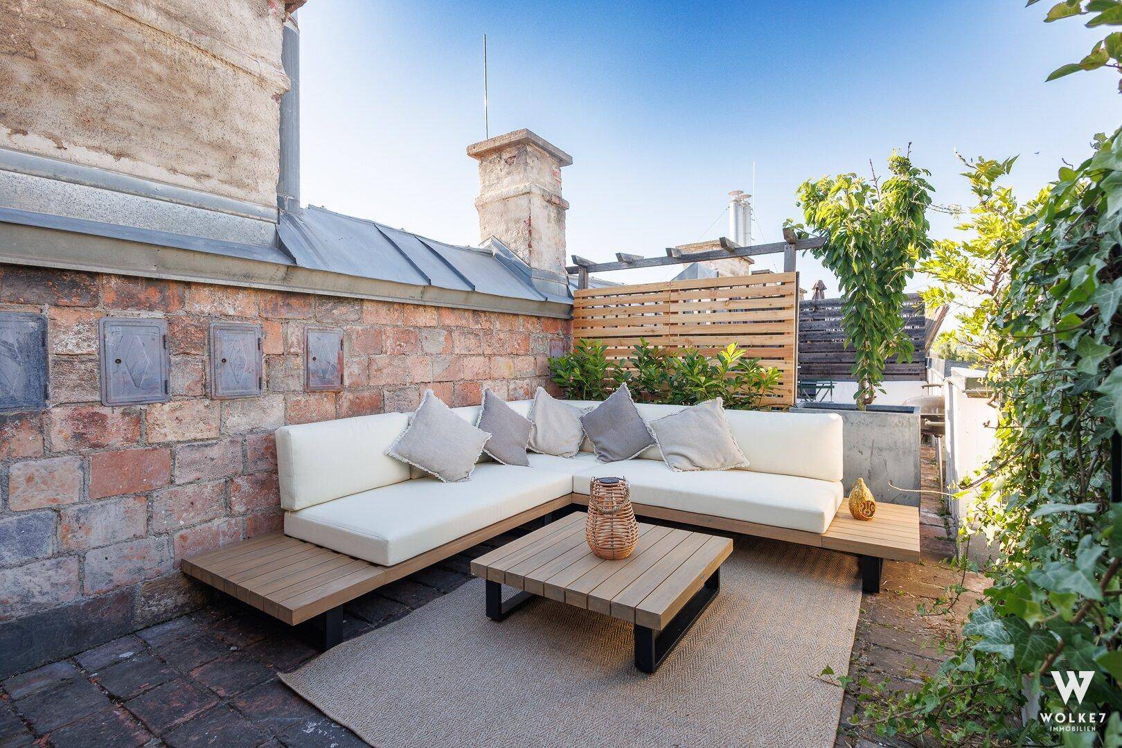 Gemütliche Dachterrasse mit bequemer Sitzecke und grünen Pflanzen für entspannte Stunden.